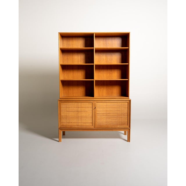 Oak and woven rattan bookcase with 28 cm-deep adjustable shelves and a lower compartment closed by two doors. "Norrland"...