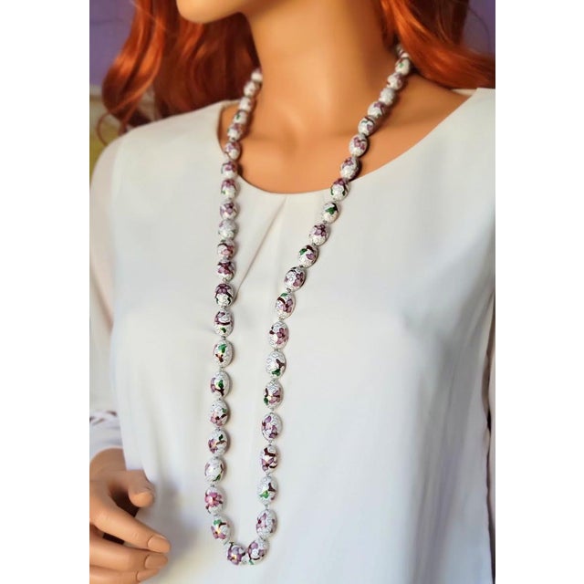 This vintage Chinese porcelain bead necklace features 50 beads with white and pink flower designs hand-painted on a light-...