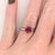 A 1.74ct Madagascar Ruby of vivid character, hand-set in 14K White Gold framed by a Diamond Halo. The cushion stone is cut...