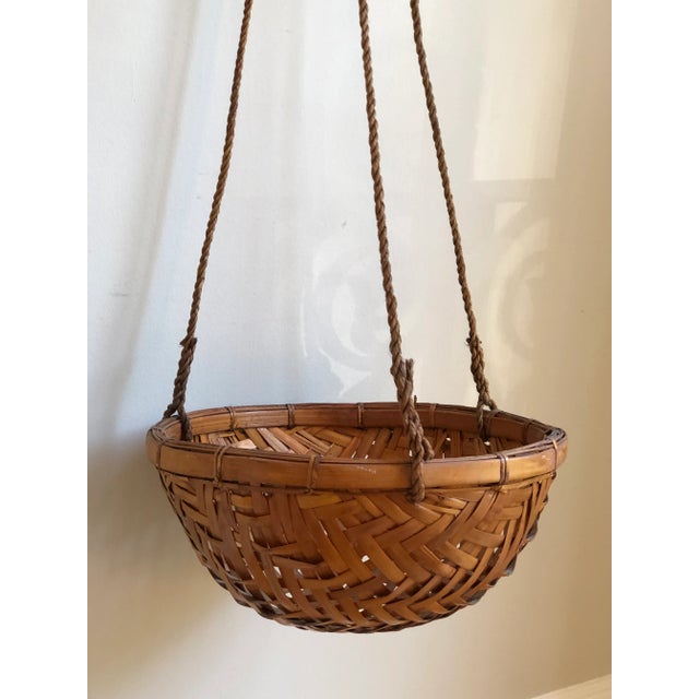 Offering a truly exquisite mid-20th century hanging basket planter of handwoven natural rattan and jute roping. This...