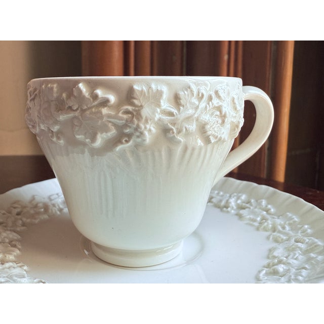 Wedgwood Queens Ware demitasse cup and saucer in cream on cream glaze. Embossed grapevine relief border with fluted cup...