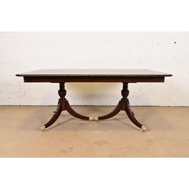 An exceptional Georgian or Regency style double pedestal extension dining table In the manner of Baker Furniture USA,...