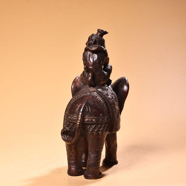An exceptional, heavy solid-copper Chinese figurine depicting a monkey riding on an elephant — the classic auspicious...