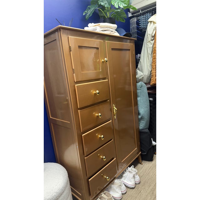 Vintage gold-painted wardrobe cabinet featuring five drawers and a tall side cabinet with interior shelving. Great for...