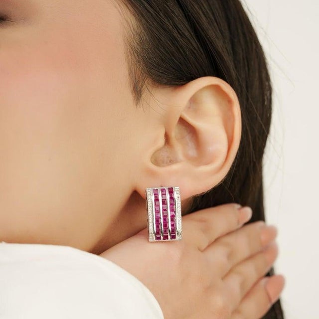 Crafted in 925 sterling silver, these striking stud earrings feature vibrant natural rubies arranged in an elegant multi-...