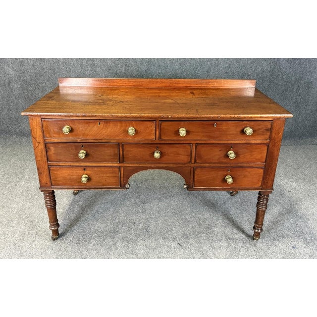 This 18th century English-made mahogany sideboard features a warm, time-softened patina, a wooden gallery, and a classic...