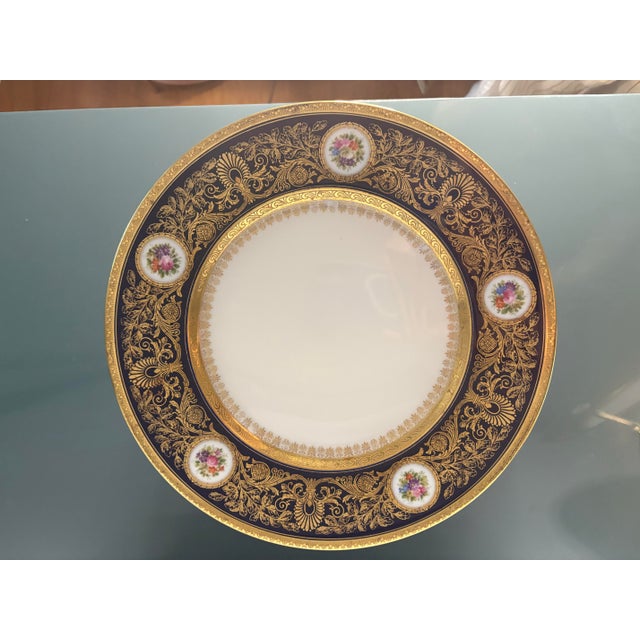 GERMAN HUTSCHENREUTHER PORCELAIN FLORAL AND COBALT-DECORATED SERVICE PLATES each featuring five circular medallions with...