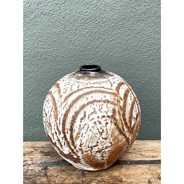 This vintage abstract ceramic vessel presents a striking, monumental spherical form, its rounded silhouette narrowing...