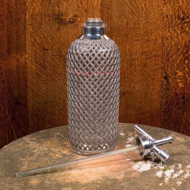 This is a vintage soda syphon. An English, glass and alloy cocktail bar drinks bottle, dating to the mid 20th century,...
