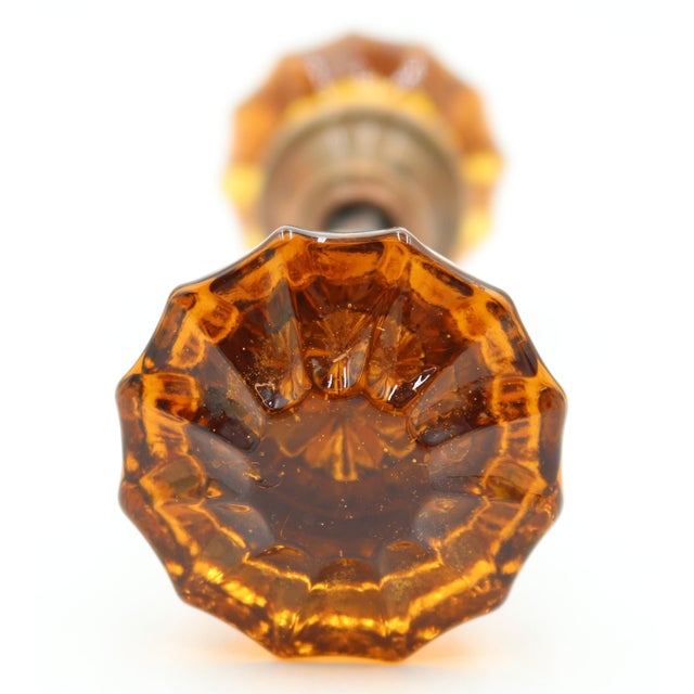Vintage fluted shaped amber glass door knobs with a brass shank. Priced as a pair of knobs with a spindle. Good condition...