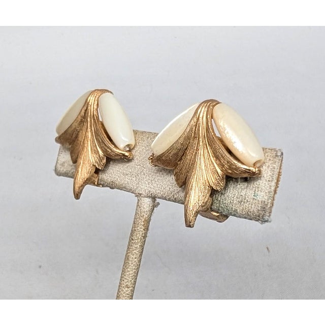 1960s textured goldtone in the shape of a leaf with two ellipsoid mother of pearl beads the top butterfly clip back...