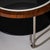 Round modernist Art Deco coffee table featuring a clear glass top and a walnut-veneered frame. The structure incorporates...