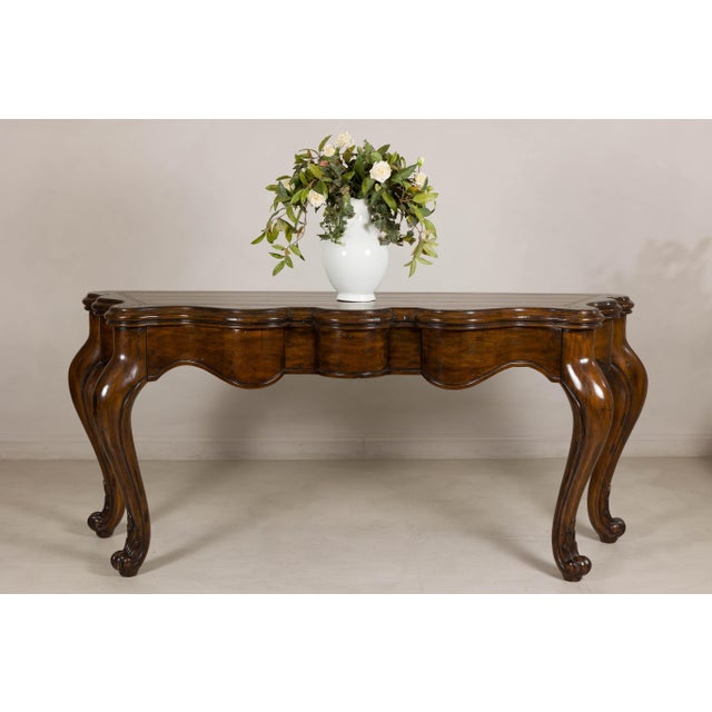 This substantial Marge Carson console table showcases the dramatic curves and elegant proportions that helped establish...