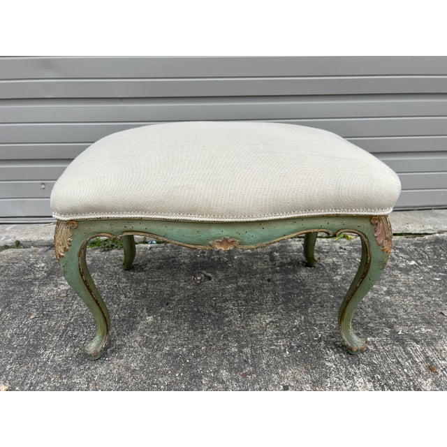 Italian Louis XV Style Painted And Gilt Bench. Offered is a lovely Italian painted and gilt wood bench or ottoman. The...