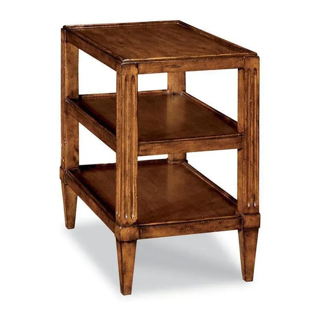 A rectangular top rests over two shelves supported by fluted corner posts that taper.