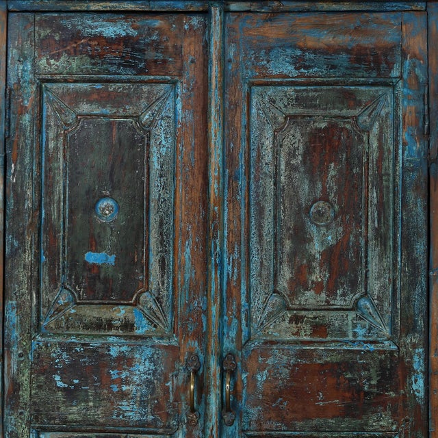 Antique Indian Small Painted Teakwood Armoire, with deeply beveled carved panels, bracket plinth, and much of its old blue...