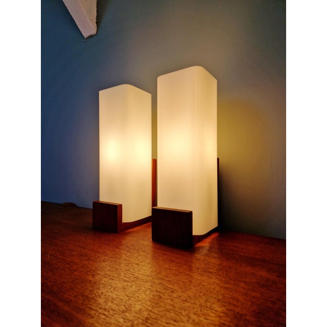 Pair of rectangular teak wall sconces with satin white opaline glass shades, designed by louis kalff for philips, auray...