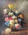 A richly detailed vintage floral still life oil on canvas, presented in an ornate gilt wood frame. The composition...