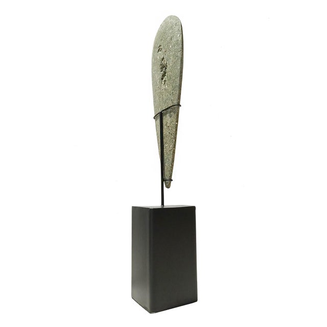 A small "blade" sculpture, hand-carved in Indonesia out of a single piece of volcanic green rock. The natural inclusions...