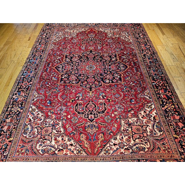 "This vintage Persian Heriz rug, woven in the renowned weaving region of Azerbaijan in Northwest Persia, features a...