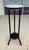 This vintage pedestal or plant stand features a round gray-and-white marble top set above a dark wood frame with elegant...