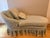 Charming vintage French Country–style chaise lounge featuring a softly curved back, rolled arm, and fully skirted base,...