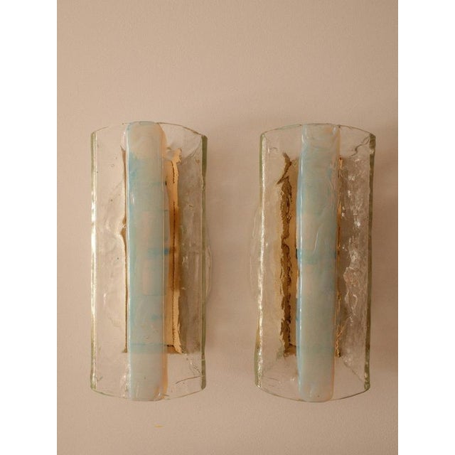 A pair of sculptural wall sconces crafted in Murano in the 1970s. Each piece features thick, hand-blown clear glass,...