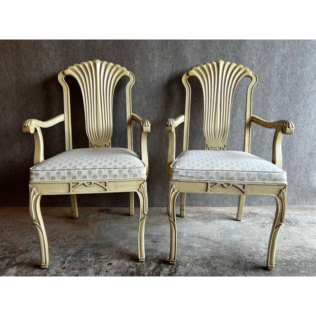 Pair of Gustavian style grotto arm chairs featuring a glossy cream, antiqued finish, fluted backs and arms and cream...