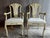 Pair of Gustavian style grotto arm chairs featuring a glossy cream, antiqued finish, fluted backs and arms and cream...