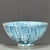 A charming Chinese ceramic tea cup or small bowl. The piece features a striking, highly textured "splash" or "flambé"...