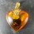 A large vintage French 18 karat (18K) yellow gold and clarified amber pendant designed as a puffy heart with sun spangle...