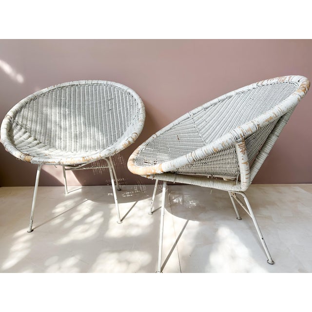 Pair of mid-century style lounge chairs featuring wicker seats and metal frames, inspired by Brazilian design of the...