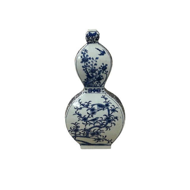 This striking Chinese blue and white porcelain bottle vase features a distinctive double-gourd silhouette reinterpreted...