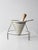 A mid-century conical strainer set with stand and wooden pestle. The perforated metal cone rests in a simple wire frame...