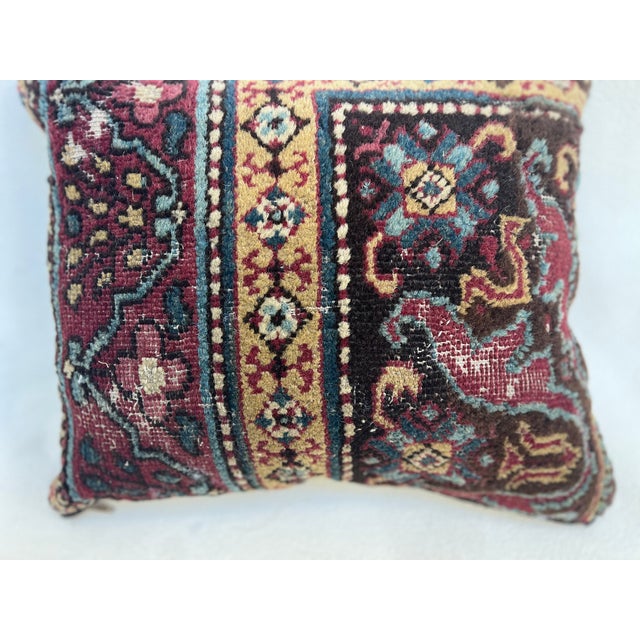 This is a pillow upholstered in a 19th century rug fragment, featuring charming tribal motifs. There is wear on several...