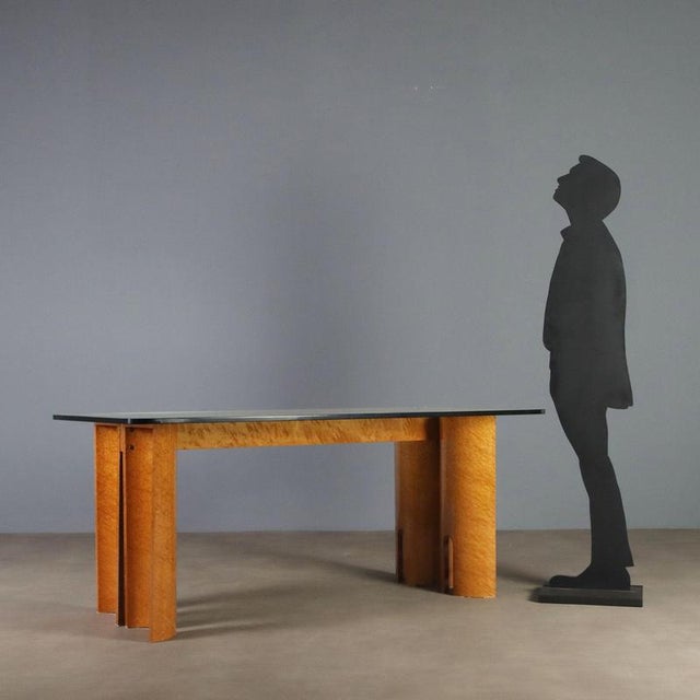 Italian-made table from the 1970s, featuring a design with great visual impact. The semicylindrical legs are adorned with...