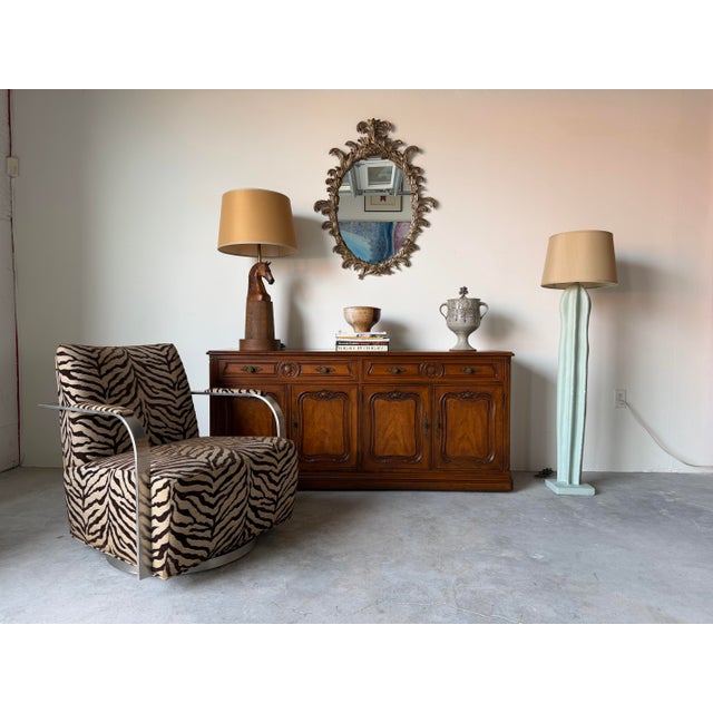 Striking THAYER GOGGIN “Zac” swivel lounge chair featuring an eye-catching zebra print upholstery paired with a sleek...
