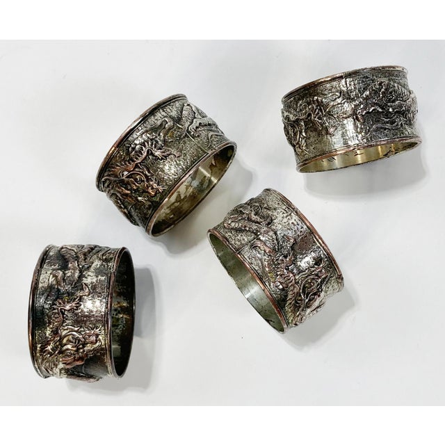 Set of four silver plated napkin rings with great detail of full length classic Chinese style dragon that wraps and...