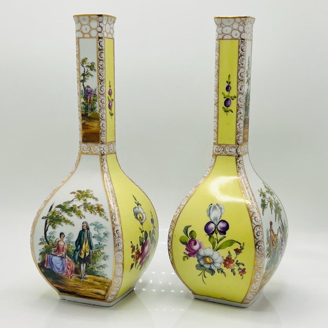 This fine pair of Dresden porcelain vases features a striking, square bulbous body paired with elegantly elongated necks....