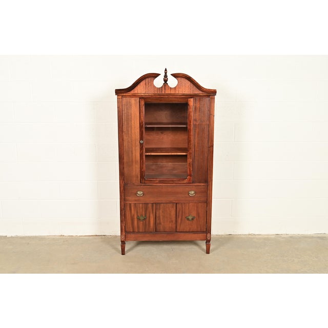 A beautiful Georgian or Federal style bookcase cabinet or dining cabinet In the manner of Baker Furniture USA, Circa 1940s...