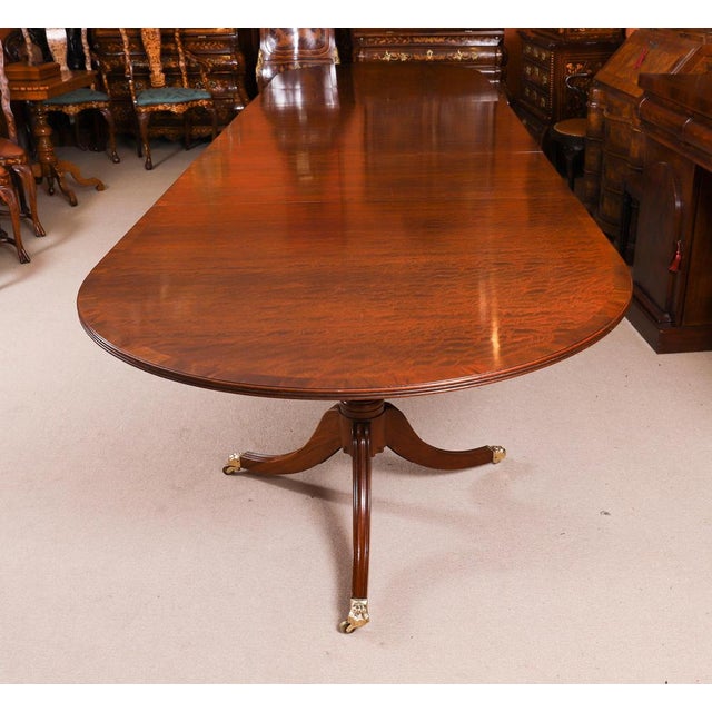 This is a fabulous Vintage Regency Revival triple pedestal dining table dating from the mid 20th Century. The table is...