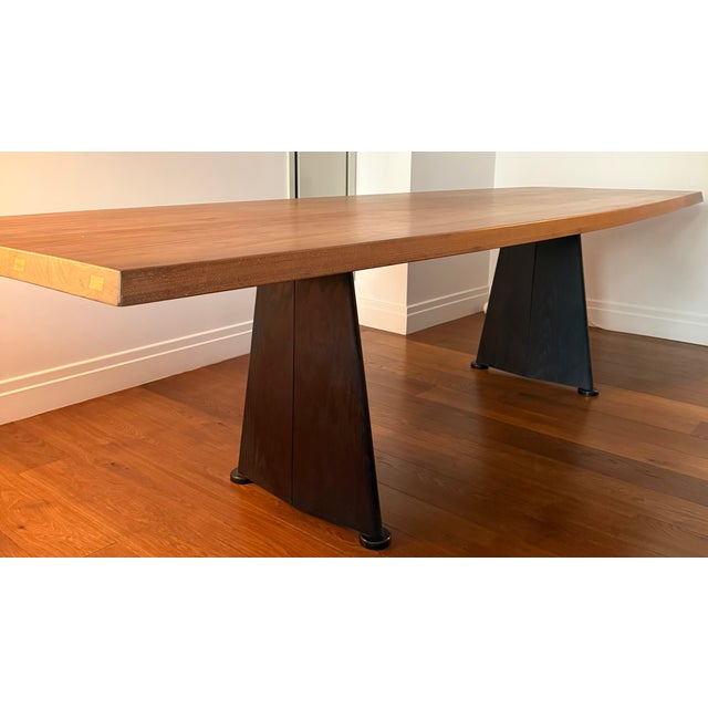 Solid Walnut Dining table with tapered 2 inch top. Wax finished. Blackened Oak legs supported on steel frame. Narrow at...