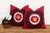 A bold black scalloped medallion anchors each pillow in this well-matched pair — a wine-red ground framing a cream ric-rac...