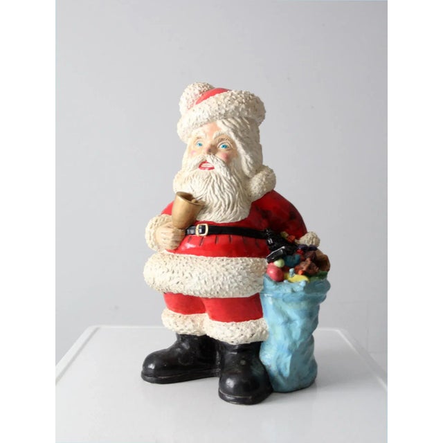 This is a 1973 Ann's Original Figurines' Santa coin bank. The large Christmas statuary features Santa carrying a bell with...