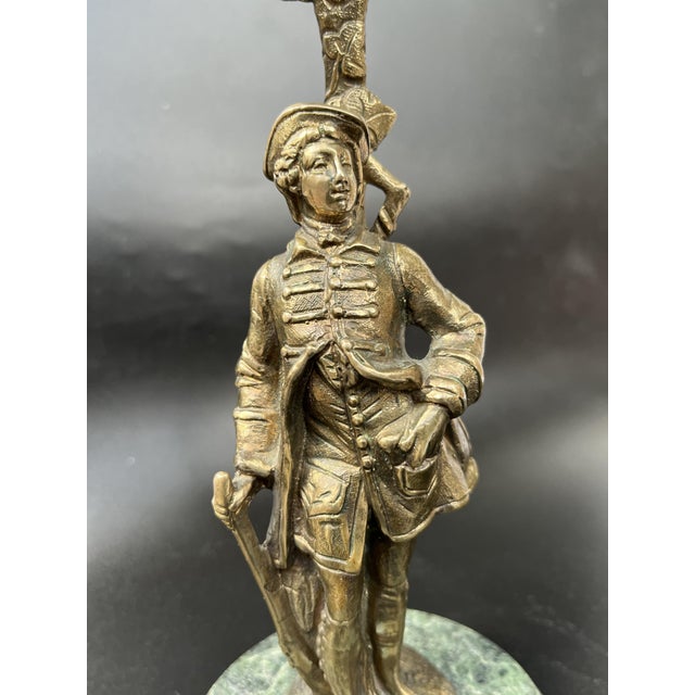 An elegant Louis XVI Revival figural bronze candelabrum featuring a standing gentleman dressed in 18th-century attire,...
