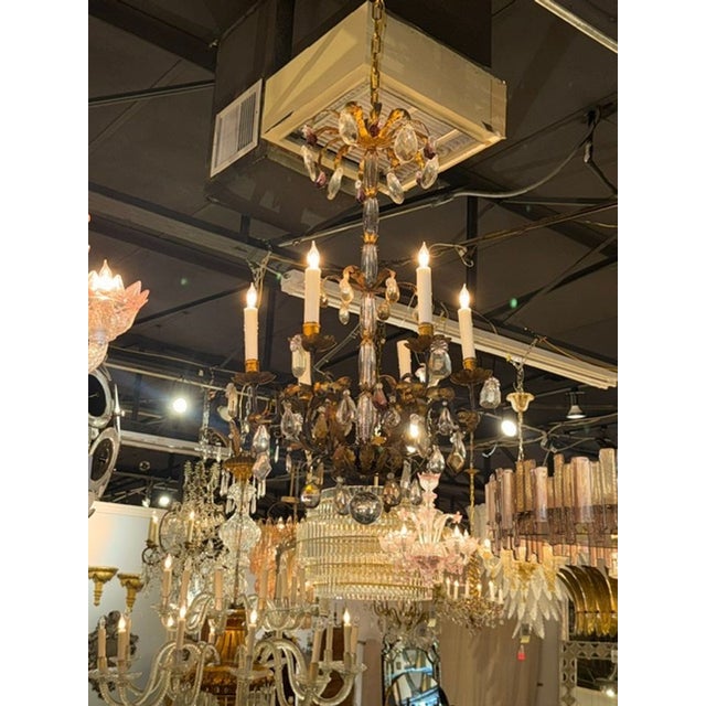 The product is an early 20th-century Italian gilt tole and crystal chandelier. It features a beautifully crafted design...