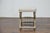 A French Empire style painted wood curule stool from circa 1900 with gilded accents, curved X-shaped legs, carved...