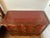 An exceptional Theodore Alexander three-drawer chest featuring a richly patinated crimson-red leather-wrapped exterior,...