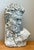 This vintage cast stone bust wall sculpture presents a compelling classical portrait, richly imbued with age and...