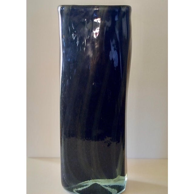 A cubic vase, entirely hand-blown from three layers of glass. The internal filaments give it a bluish sheen. This piece is...